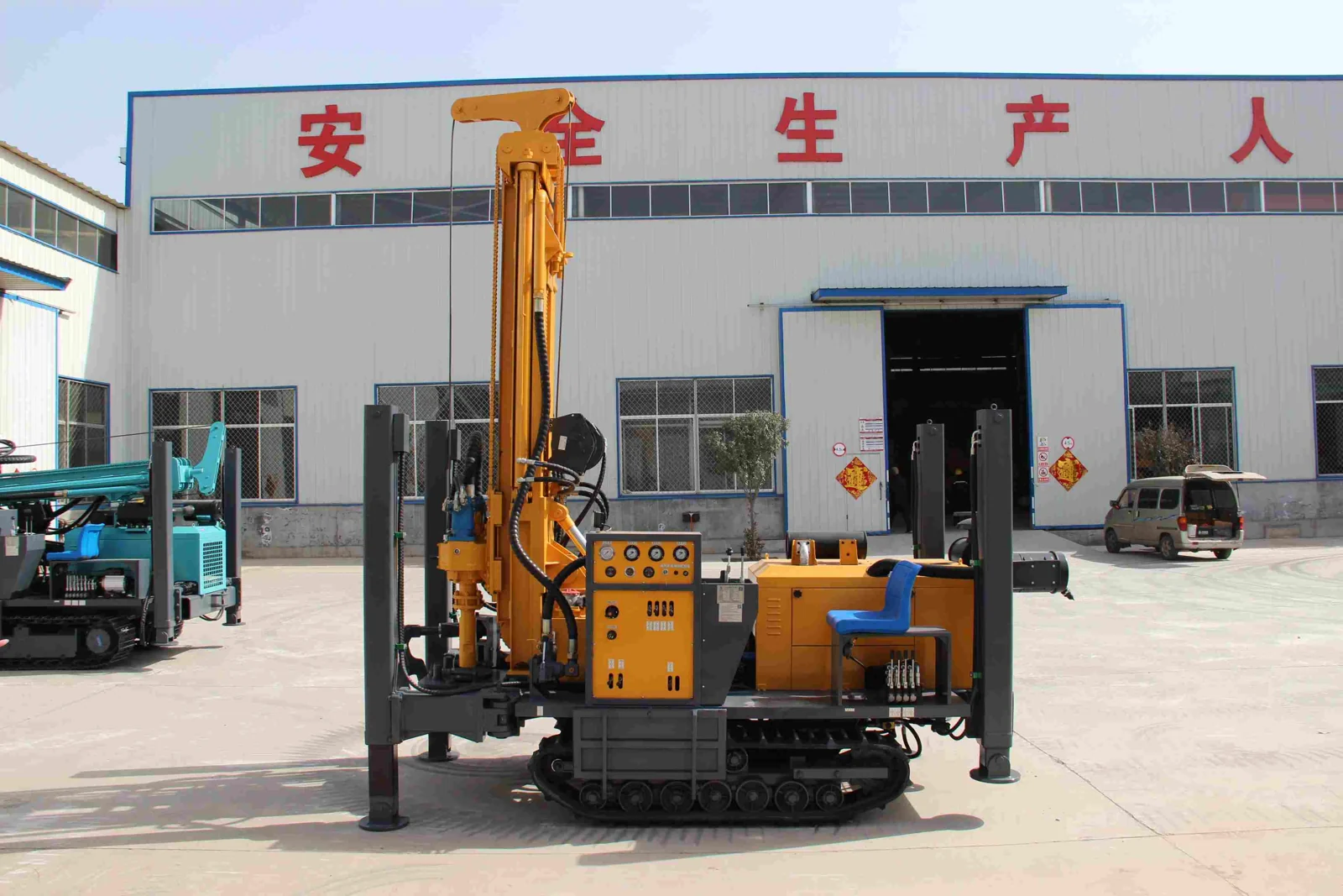 Crawler-mounted water well drilling rig with its mast raised and stabilizers extended.
